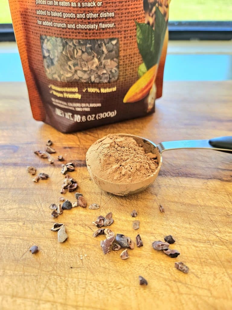 Cacao powder and cacao nibs displayed on a cutting board.