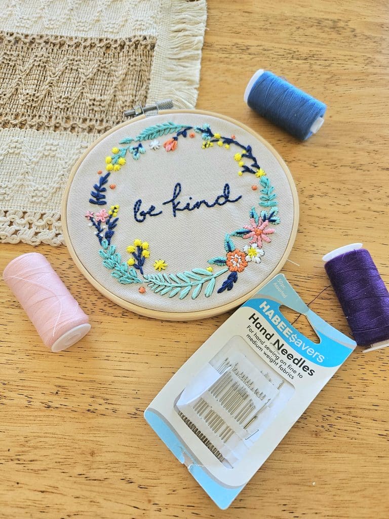 Learn new skills as a stay at home mom. Embroidery on a table with needle and thread.