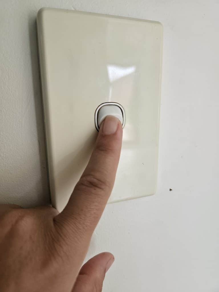 Turning off light switch to save power.