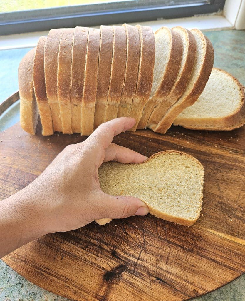 Soft fluffy sourdough sandwich bread sliced on a cutting board.