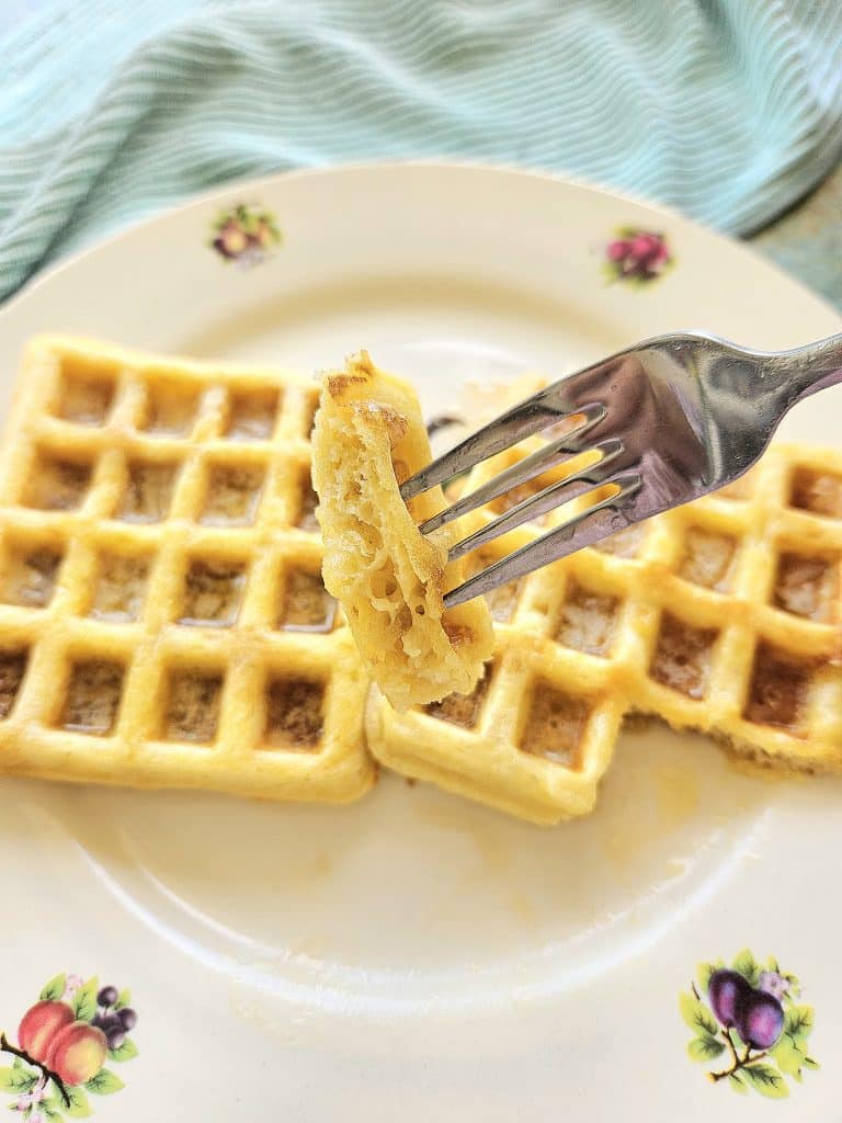 Sourdough waffles on a plate. A piece of sourdough waffle on a fork.