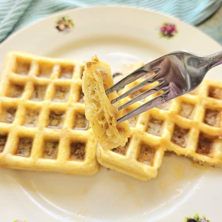 Sourdough waffles on a plate. A piece of sourdough waffle on a fork.