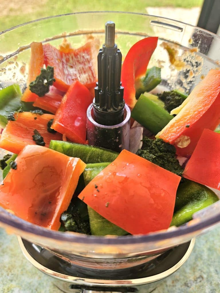 Chopped up capsicum, tomatoe, onion and herbs in a blender.