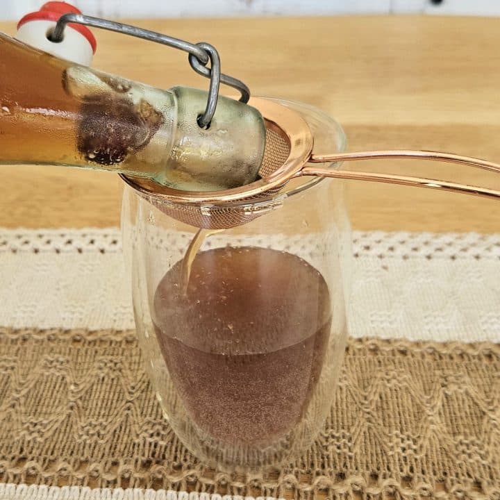 Pouring water kefir soda into a glass.