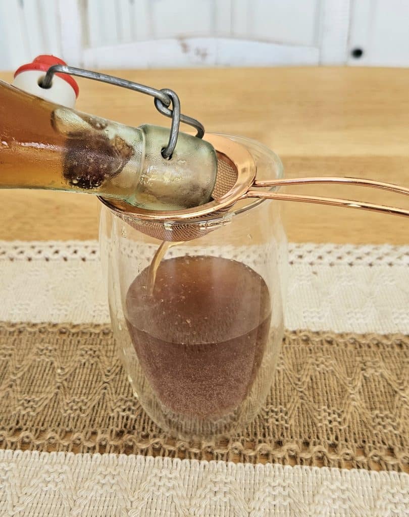 Pouring water kefir soda into a glass.