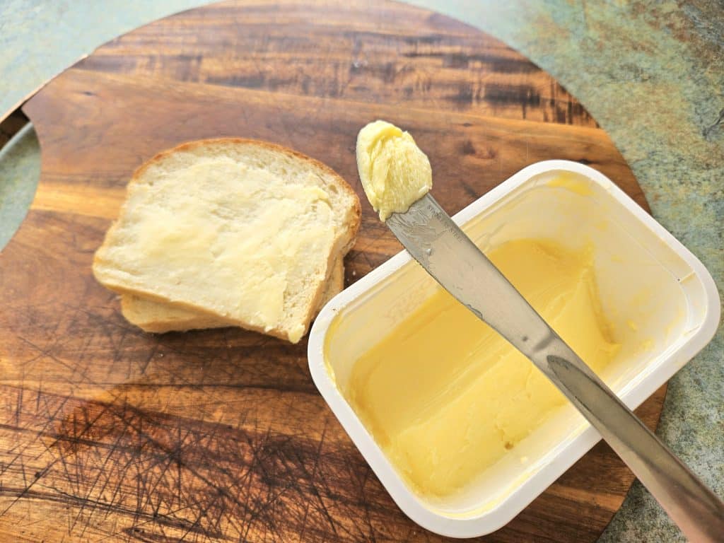 Homemade spreadable butter on a knife and on a piece of toast.