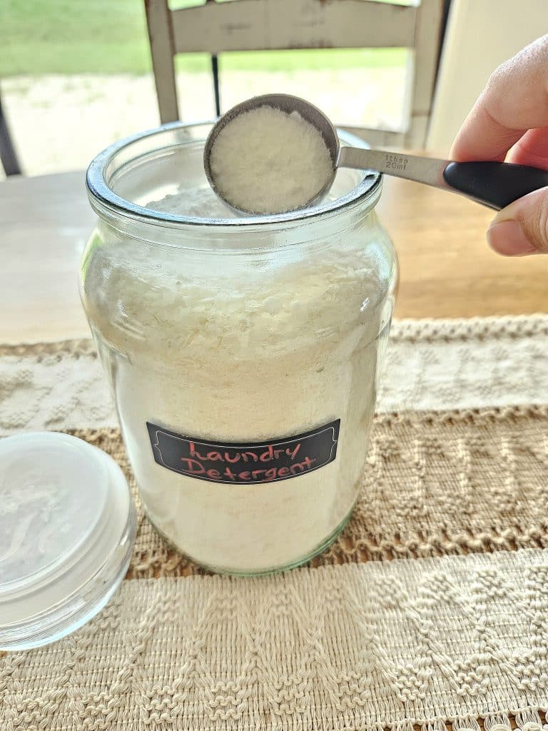 Homemade natural laundry on a table. One tablespoon being scooped out.