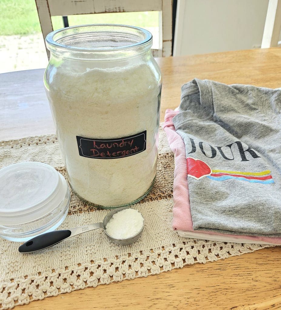 Homemade laundry powder in a glass container on a table.