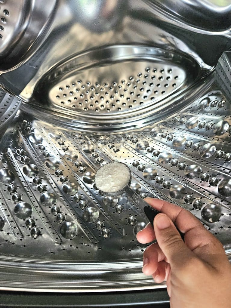 pouring laundry detergent in front loader.