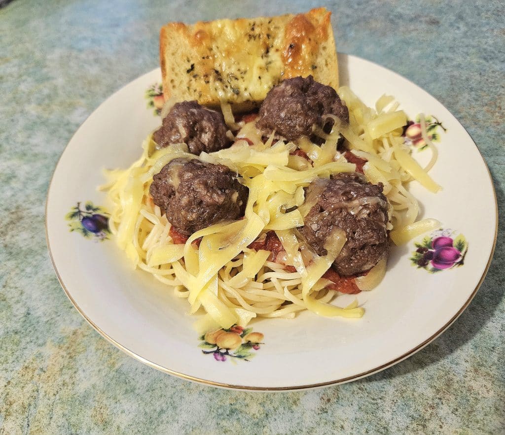 homemade meatballs served with spaghettis and garlic bread.