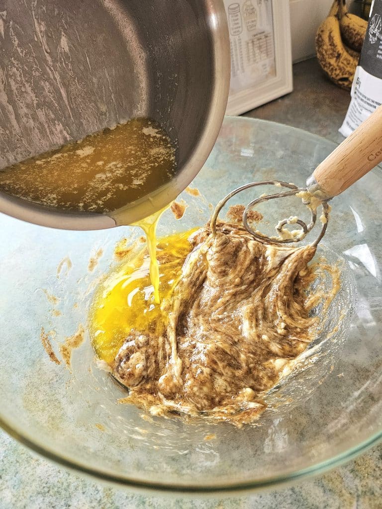 Mixing sourdough cinnamon roll ingredients together in a bowl.