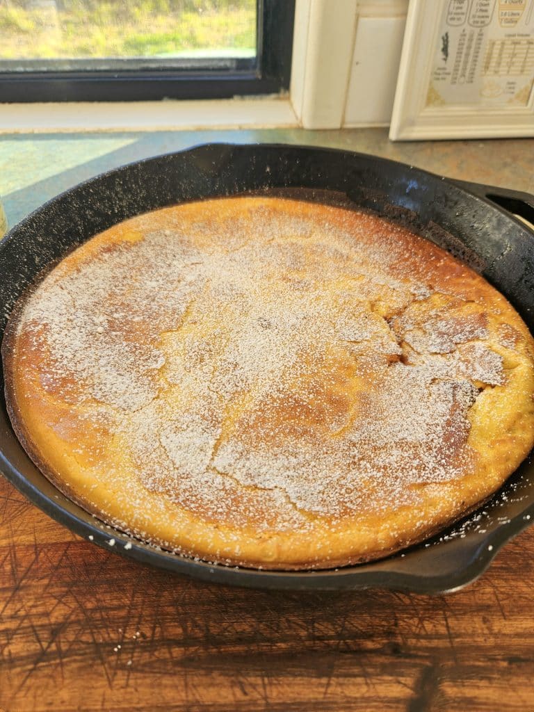 Sourdough Dutch pancake cooling in a cast iron pan.