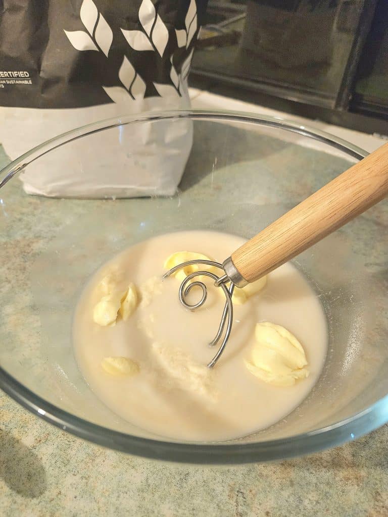 Whisking together sourdough bread ingredients.