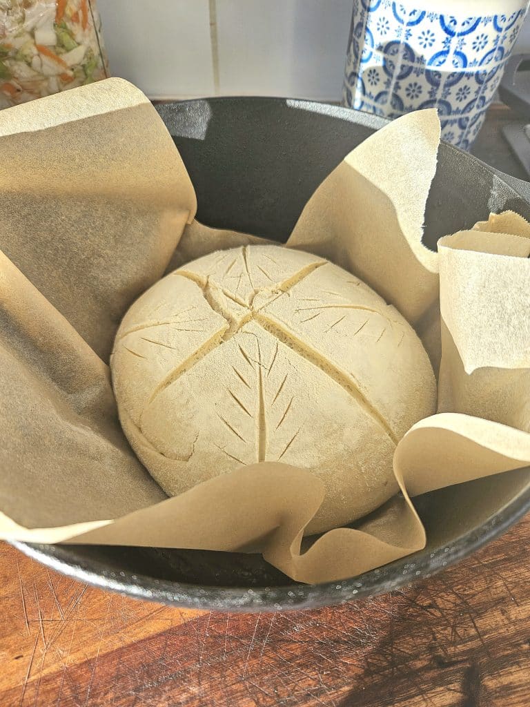 Preparing bread for baking in a cast iron pan.