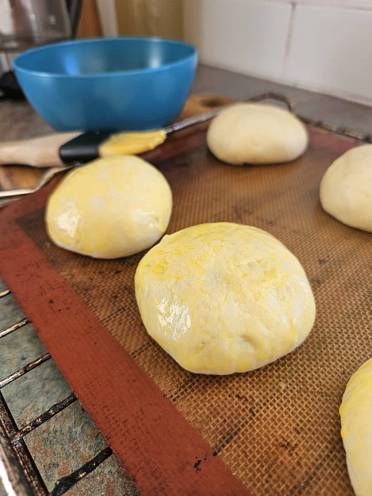 Prepping hamburger buns for the oven.