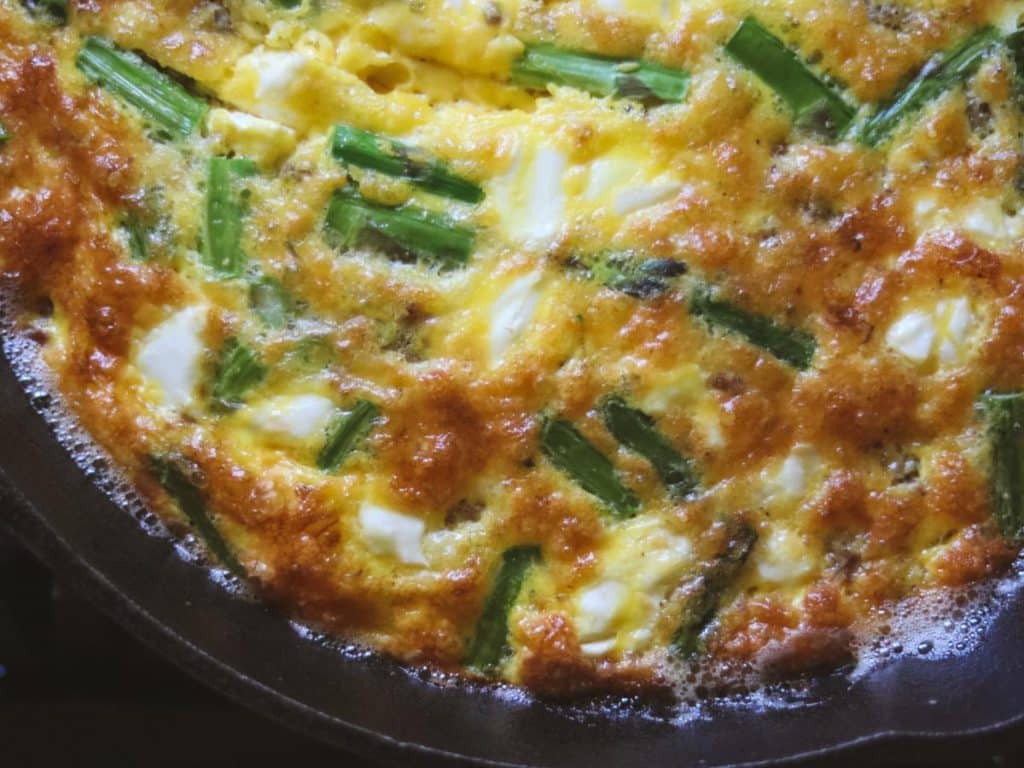 Delicious breakfast frittata cooking in a cast iron pan. 