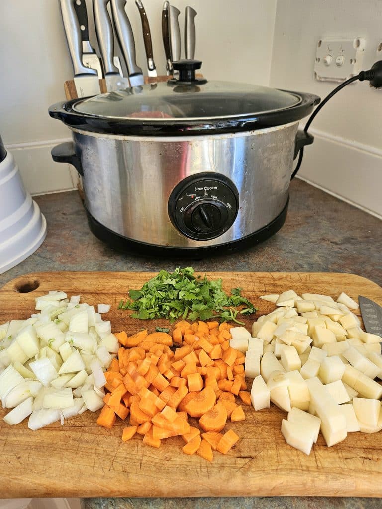 Beef stew ingredients prepped in front of a slow cooker.