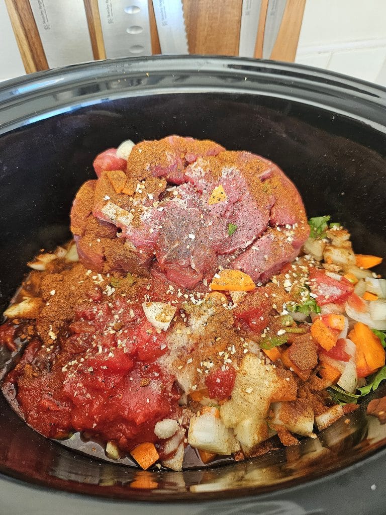 Meat and ingredients in a slow cooker ready to cook.