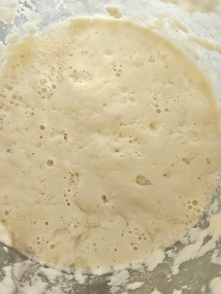 Bubbly sourdough starter in a jar.