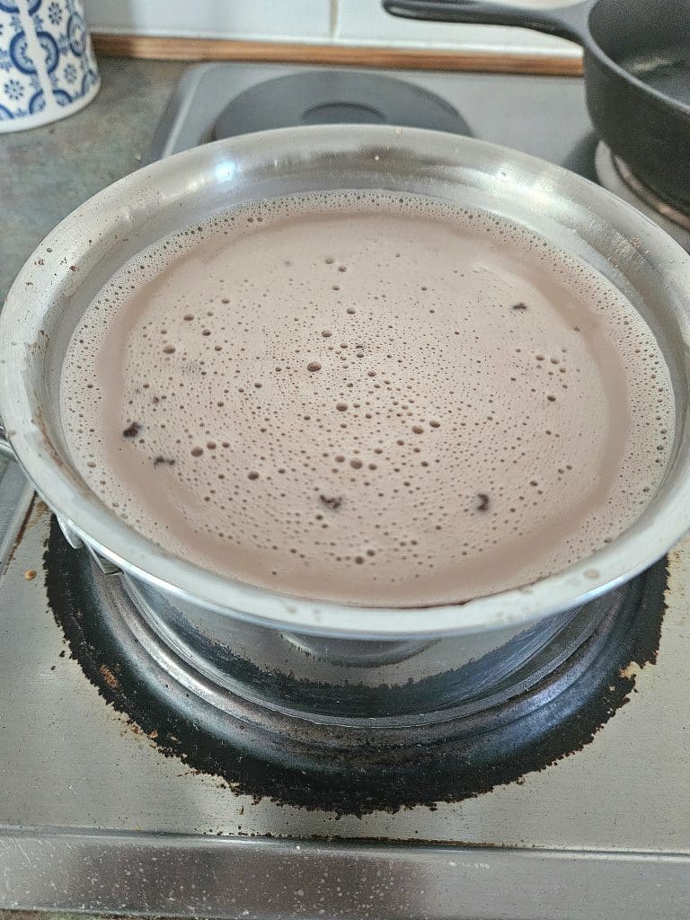 Hot cocoa heating up in a pot.