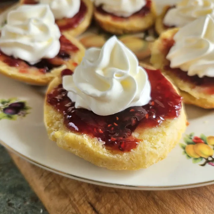 Sourdough scones topped with jam and cream.