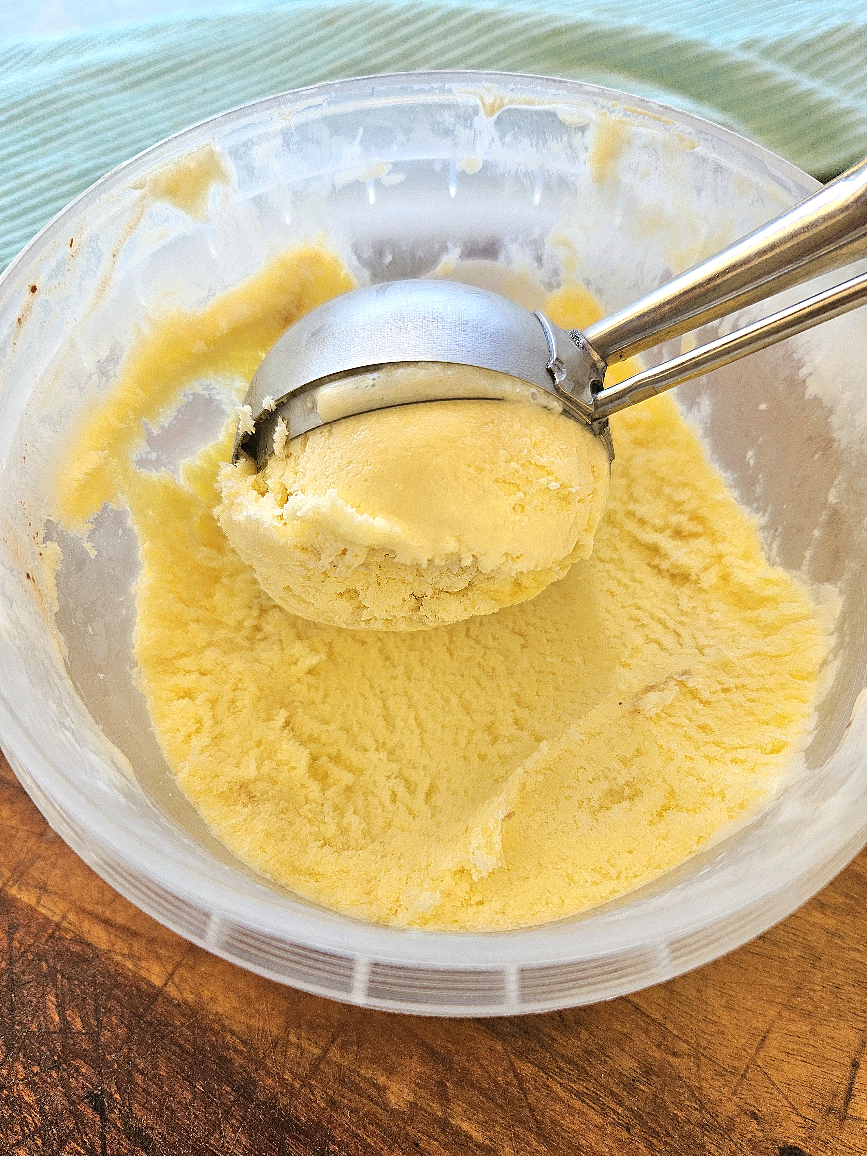 Vanilla ice cream being scooped out of a container.