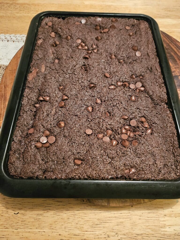 homemade brownies ready to be sliced on a baking tray.