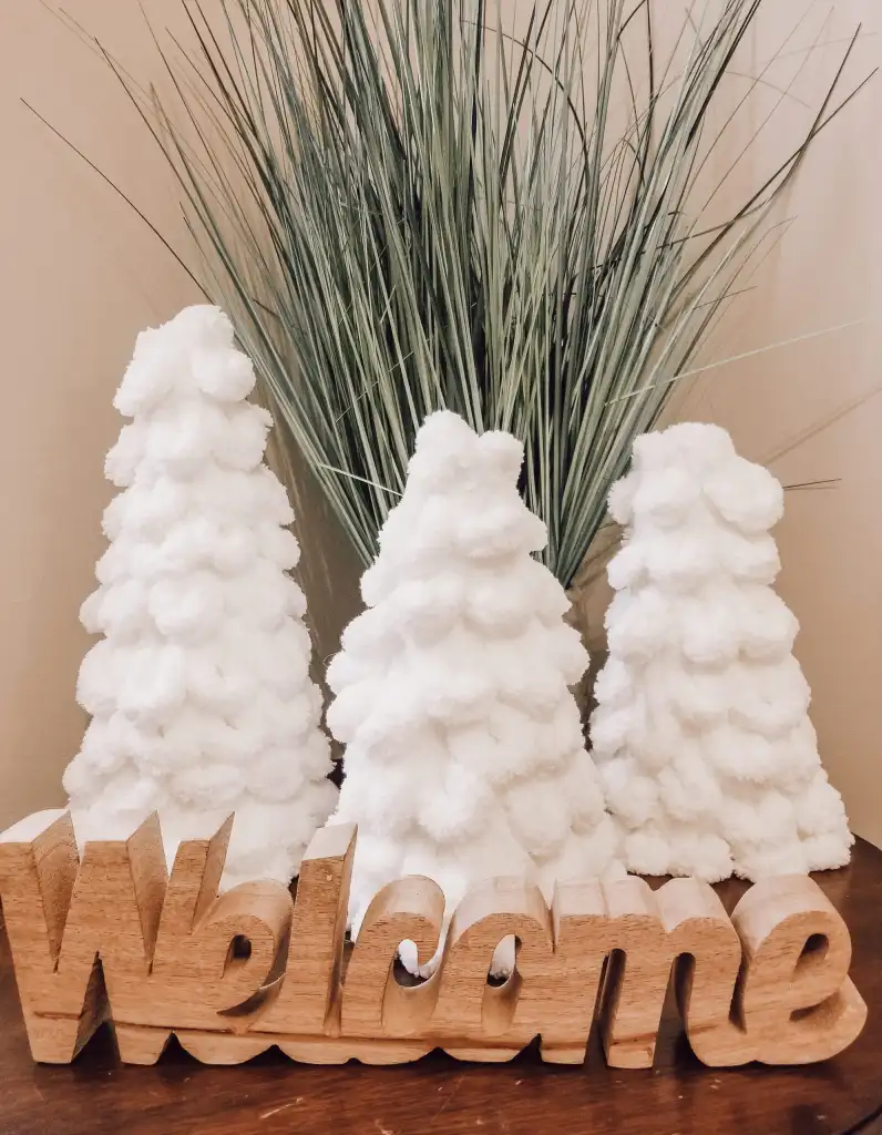 Homemade Christmas decor. White Christmas trees on a table.