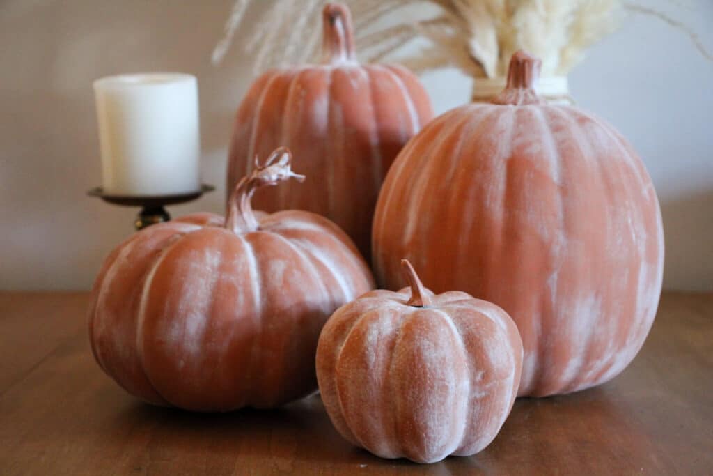 Diy faux terra cotta pumpking pots displayed as a beautiful DIY fall decoration. 