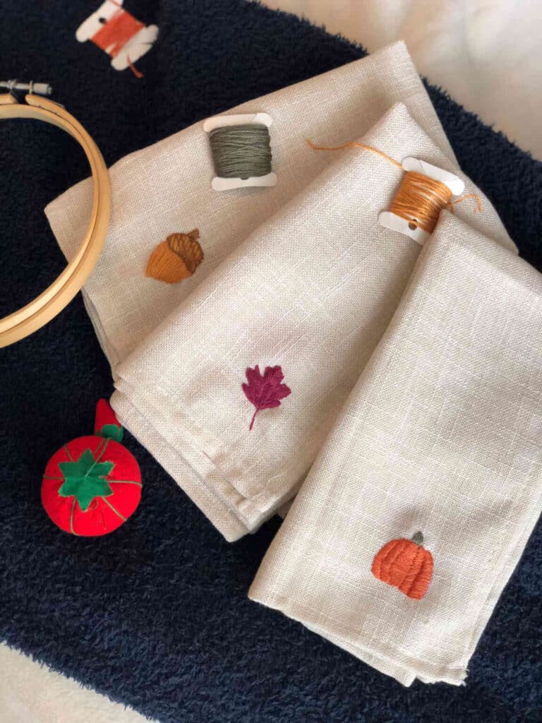 Embroidered fall napkins on a table.