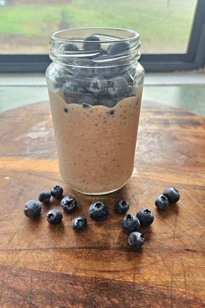 Chocolate chia pudding tipped with blueberries in a jar.