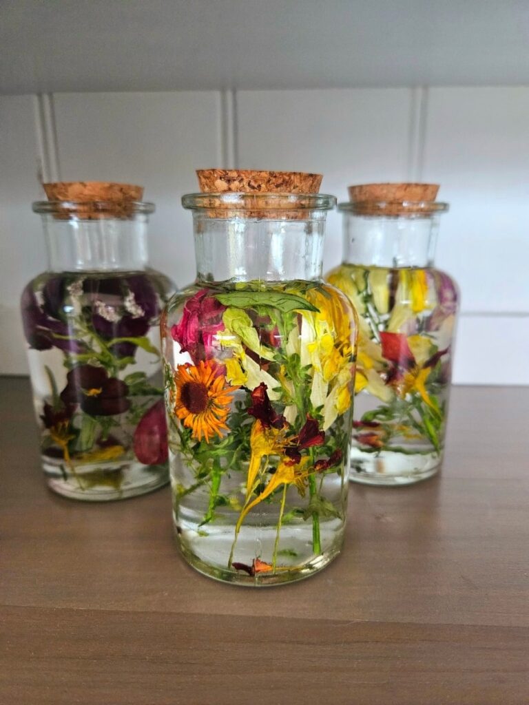 Dried flowers preserved in baby oil in a jar.