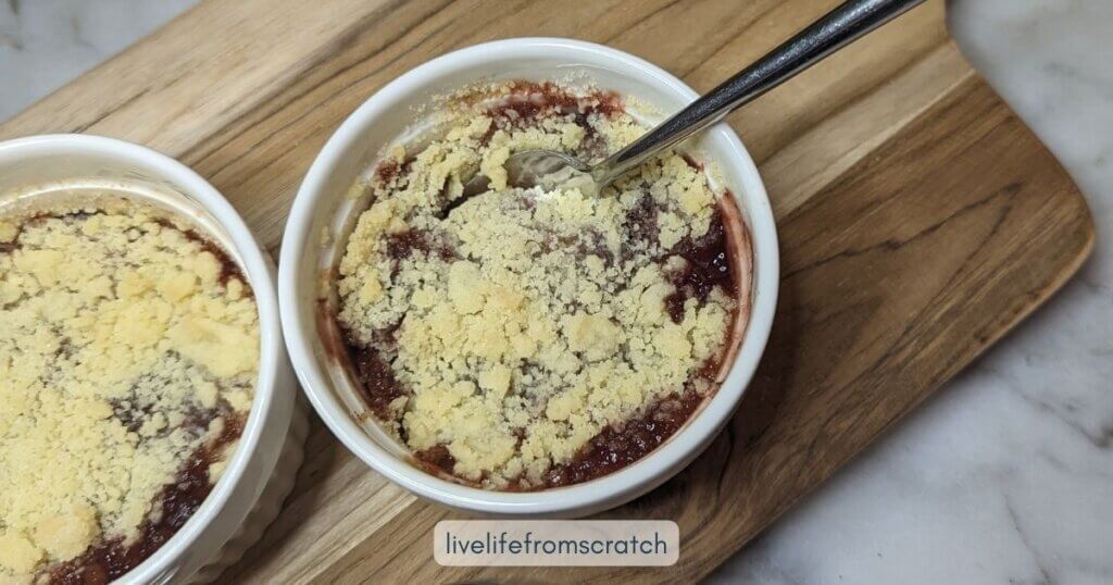 Stewed pear crumble served in ramekins on a table.