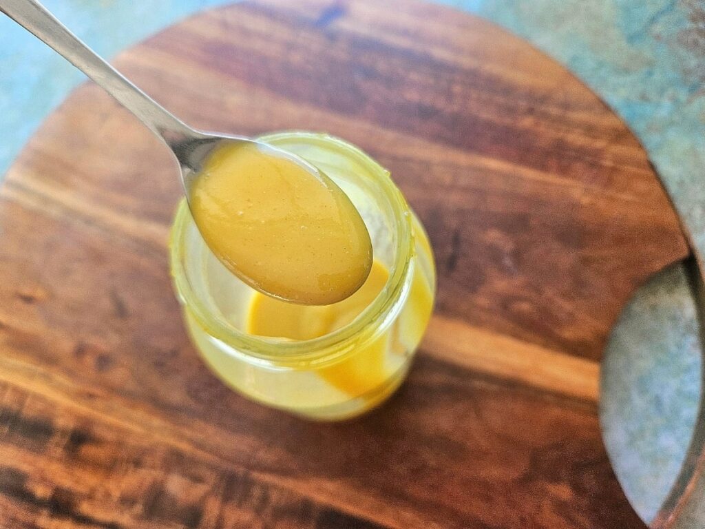 Thick and creamy honey mustard on a spoon.