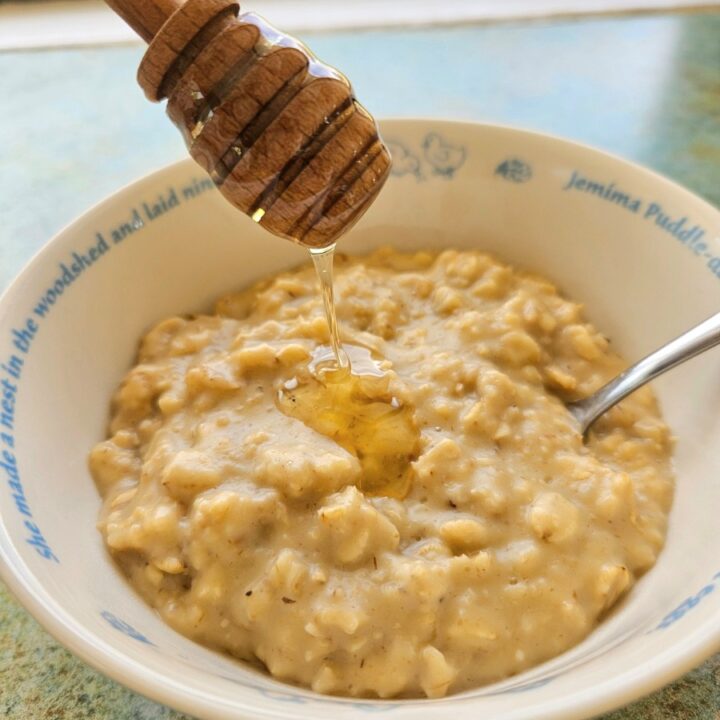 Homemade creamy oatmeal in a bowl topped with honey.