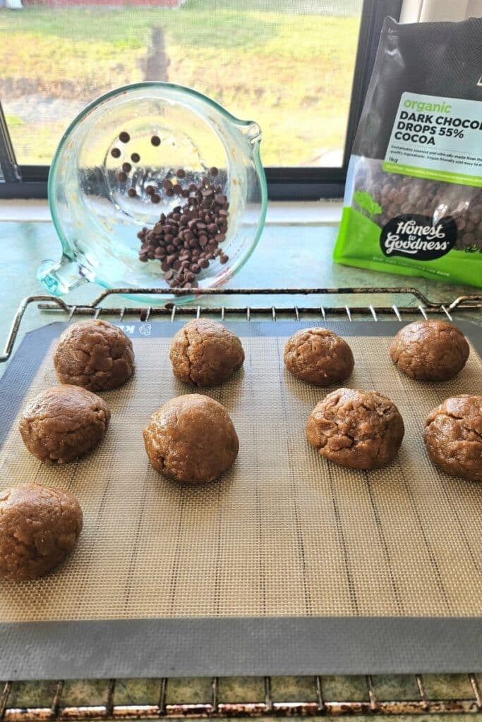 Rolling s'more cookie balls into chocolate chips.