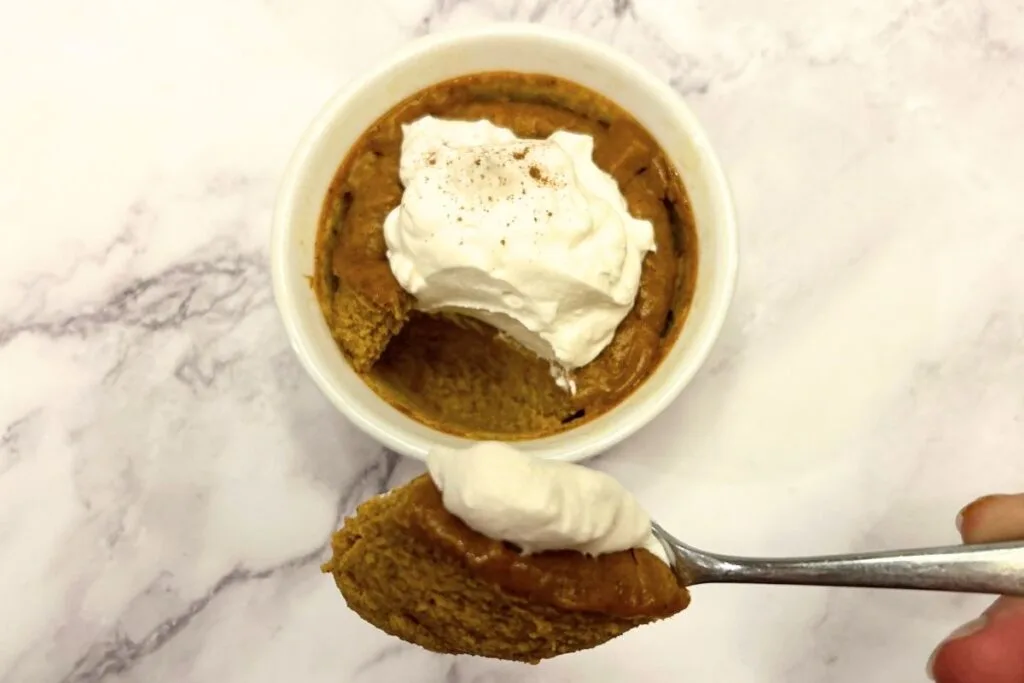 Maple custard pumpkin served in a ramekin topped with whipped cream.