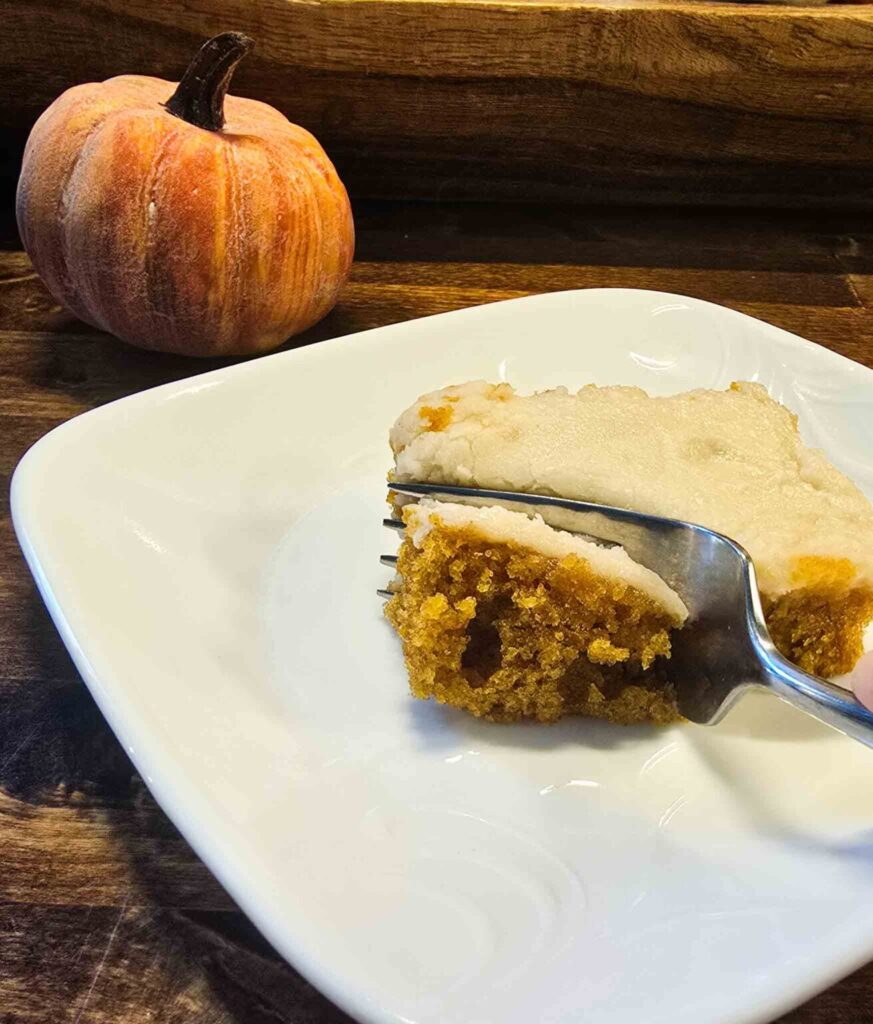 Soft homemade pumpkin bar topped with cream cheese frosting.