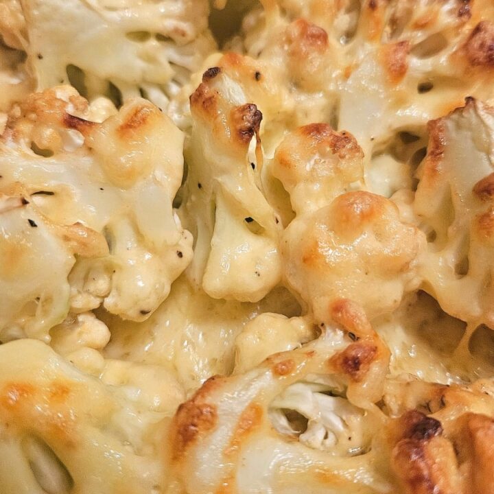 Cheesy, creamy baked cauliflower in a tray.