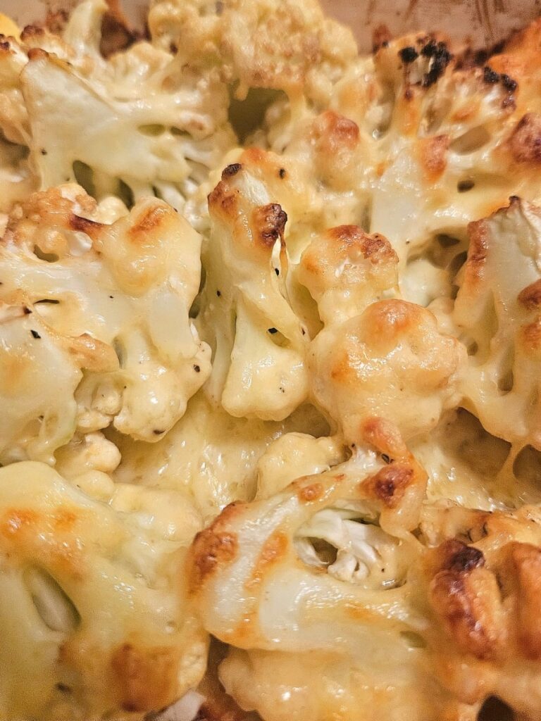 Cheesy, creamy baked cauliflower in a tray.