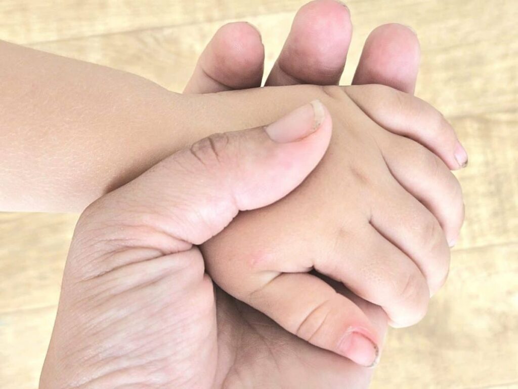 Holding little child's hands.