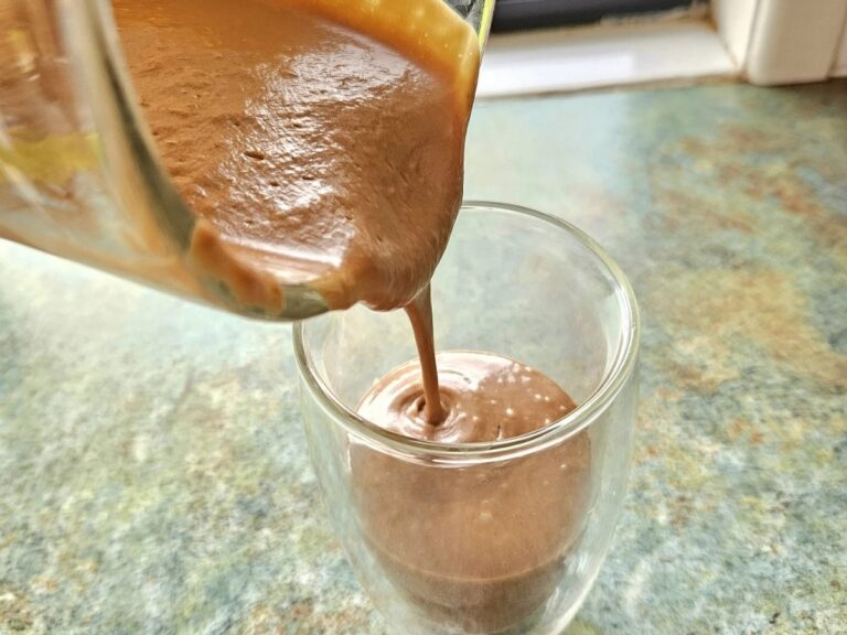 Pouring chocolate Avocado Smoothie in a cup.