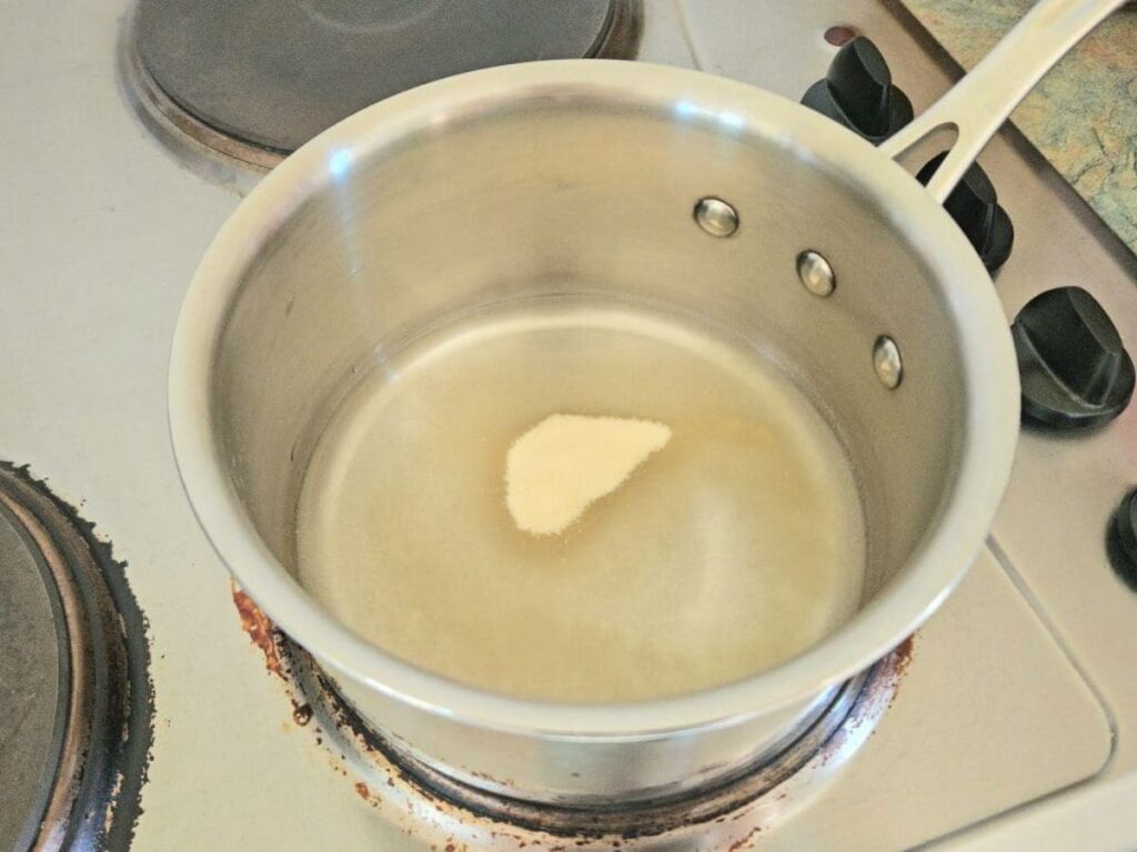 Blooming gelatin in a small pot.