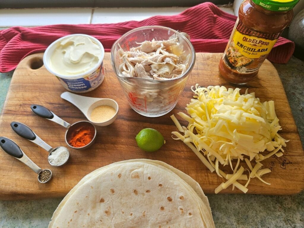 Chicken enchilada ingredients on a cutting board.