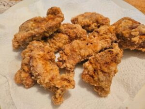 Crispy homemade gluten free chicken tenders on a plate.