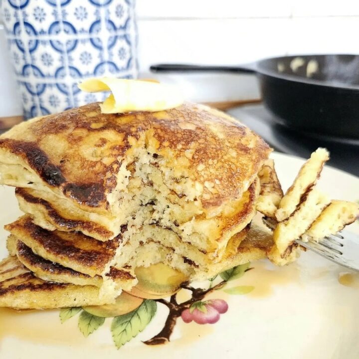 Fluffy Sourdough Pancakes stacked on top of each other on a plate.