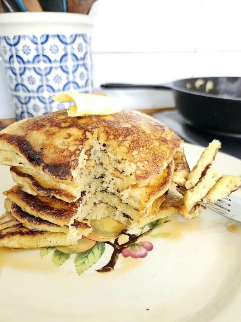 Fluffy Sourdough Pancakes stacked on top of each other on a plate.