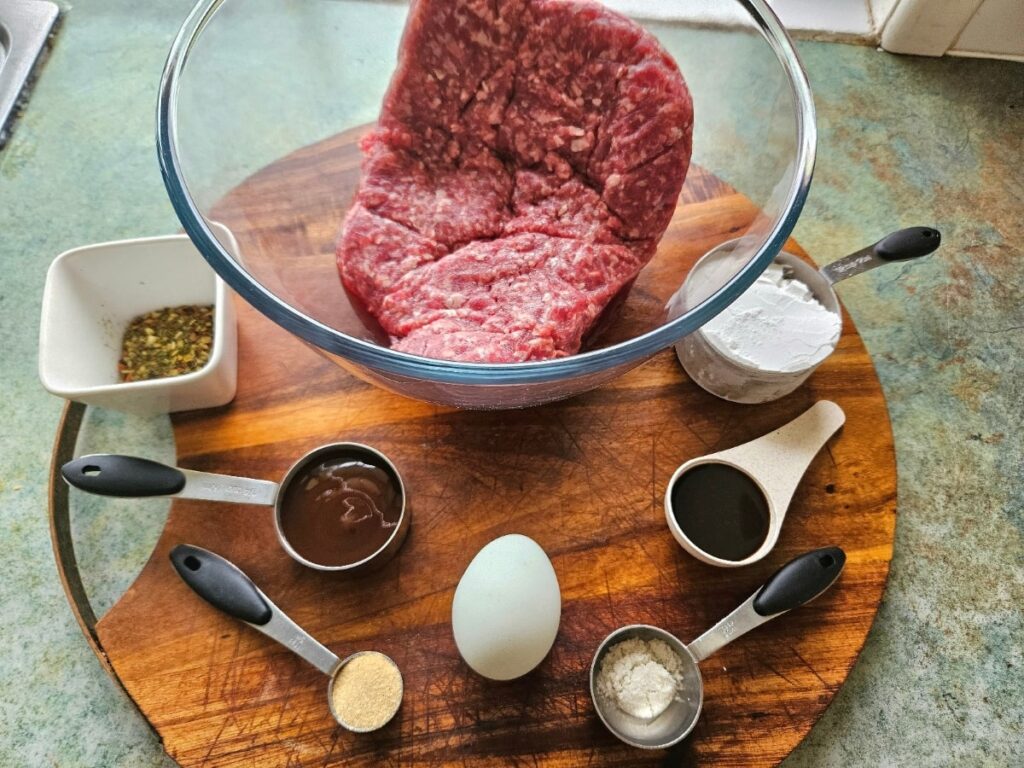 Hamburger patty ingredients on a cutting board.