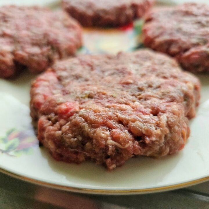 Homemade hamburger patty on a plate.