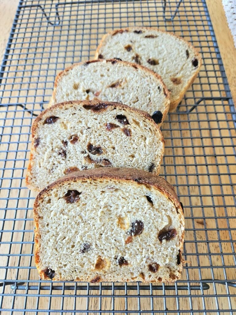 Homemade sourdough raisin toast sliced on a cooling rack.